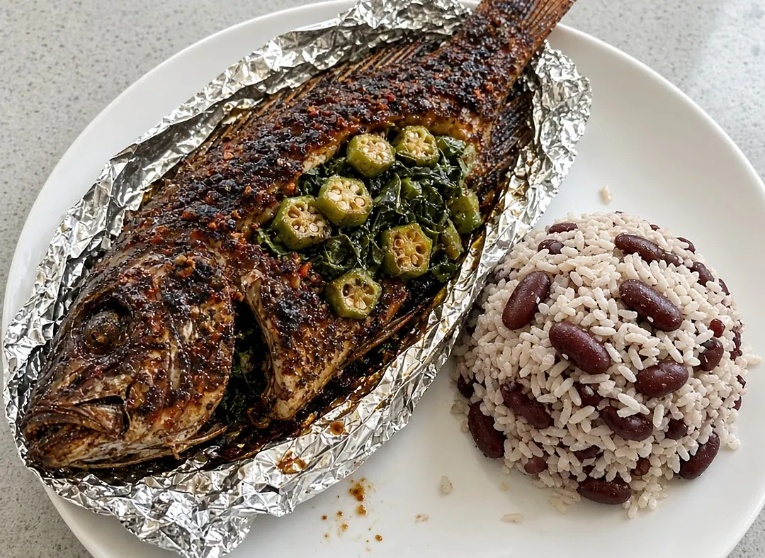 Whole roast jerk fish in foil stuffed with okra and callaloo, with rice and peas